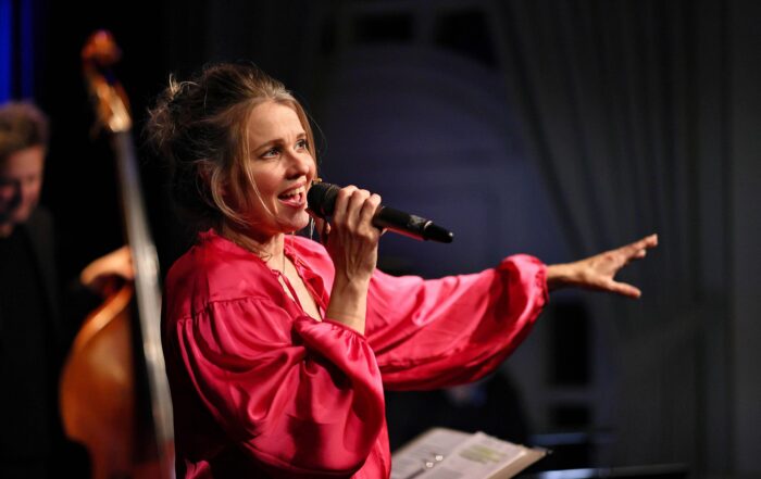 Marie Fredriksson sjunger med mikrofon i handen