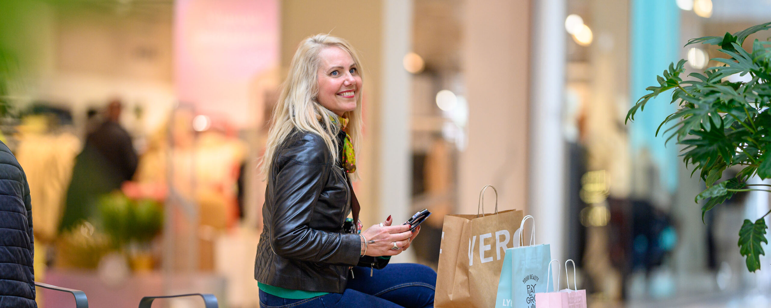 Kvinna med presentkort och shoppingkassar